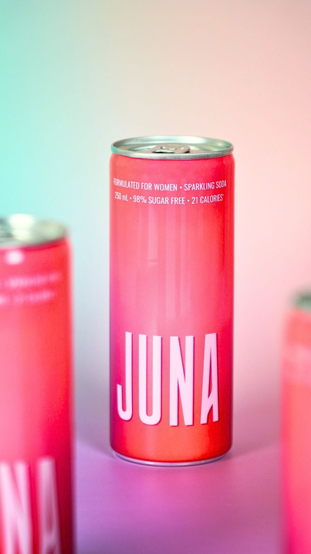 Red JUNA sparkling soda can on a soft pastel gradient background, showcasing a functional drink formulated for women’s hormonal wellness